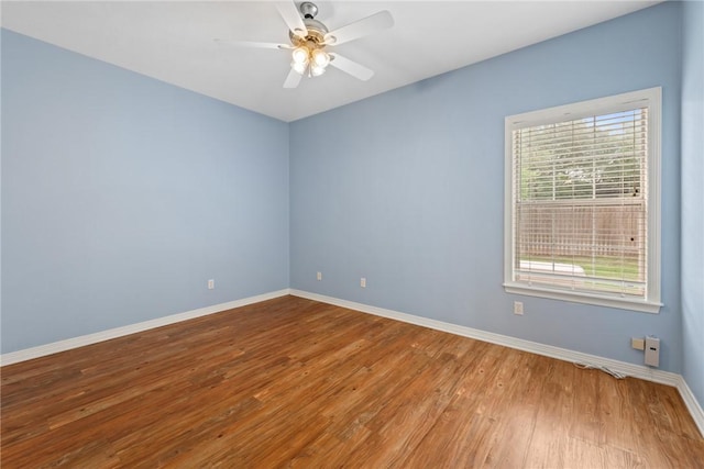 spare room with wood finished floors, baseboards, and ceiling fan