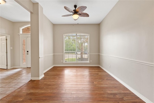 spare room with wood finished floors, ceiling fan, and baseboards