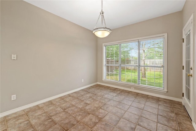 spare room with baseboards and tile patterned floors