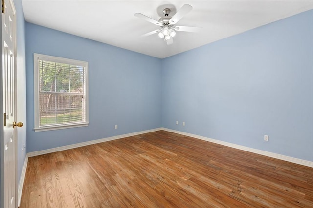 unfurnished room with baseboards, ceiling fan, and wood finished floors