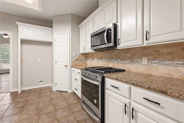 kitchen featuring stainless steel appliances, backsplash, white cabinets, and light stone counters