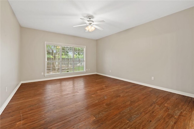 empty room featuring a ceiling fan, baseboards, and wood finished floors
