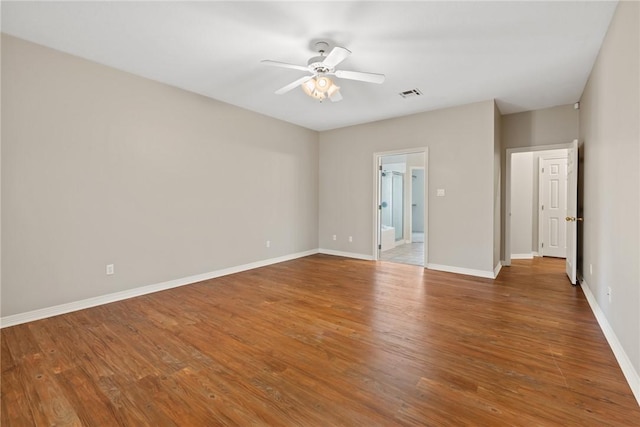 empty room with a ceiling fan, baseboards, and wood finished floors