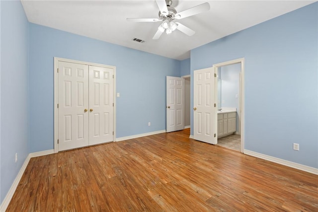 unfurnished bedroom with light wood-style flooring, baseboards, a closet, and a ceiling fan