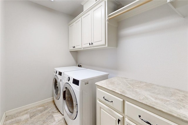 clothes washing area featuring cabinets and washing machine and dryer