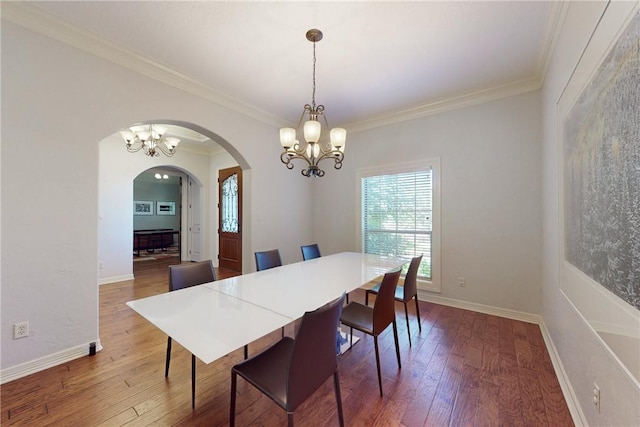 dining space with hardwood / wood-style floors, ornamental molding, and a chandelier