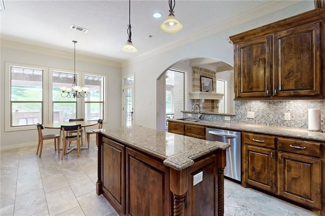 kitchen featuring stainless steel dishwasher, sink, decorative light fixtures, an inviting chandelier, and a kitchen island