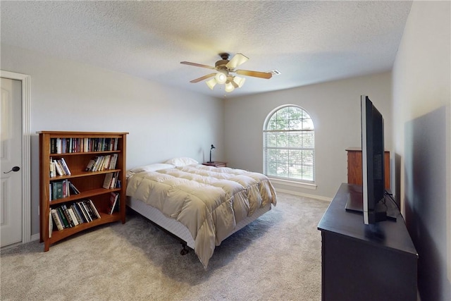 carpeted bedroom featuring ceiling fan and a textured ceiling