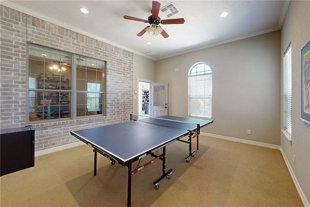 rec room with ceiling fan, carpet, brick wall, and ornamental molding