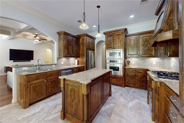 kitchen featuring decorative backsplash, stainless steel appliances, a kitchen island, and sink