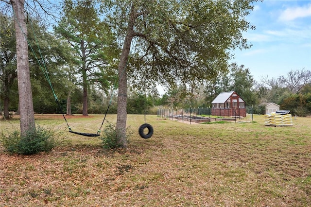 view of yard featuring a storage shed, a garden, and an outbuilding