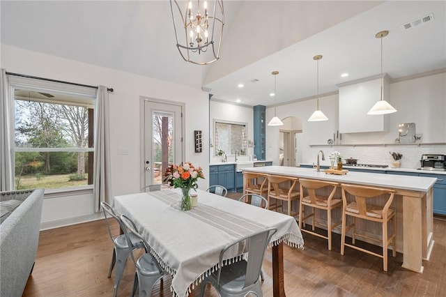 dining space featuring dark wood-style floors, plenty of natural light, visible vents, and a chandelier