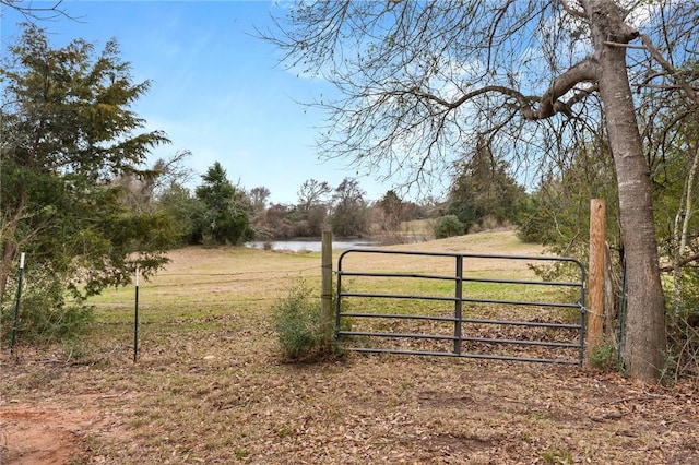 view of gate featuring a water view and a rural view