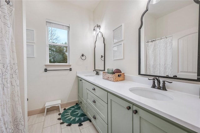 bathroom with double vanity, baseboards, a sink, and tile patterned floors