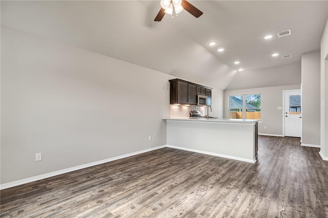 kitchen featuring lofted ceiling, ceiling fan, appliances with stainless steel finishes, dark hardwood / wood-style flooring, and kitchen peninsula