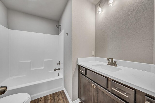 full bathroom with hardwood / wood-style floors, vanity, toilet, and shower / bathtub combination