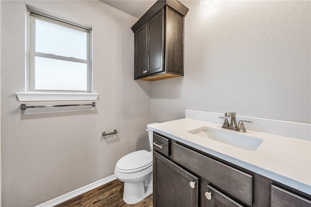 bathroom with hardwood / wood-style flooring, vanity, and toilet