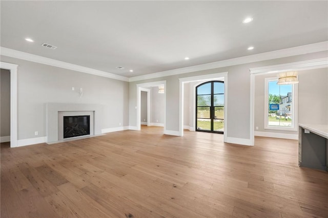4724 Concordia Dr, Bryan, TX 77802 - unfurnished living room with baseboards, crown molding, a glass covered fireplace, and light wood-style flooring