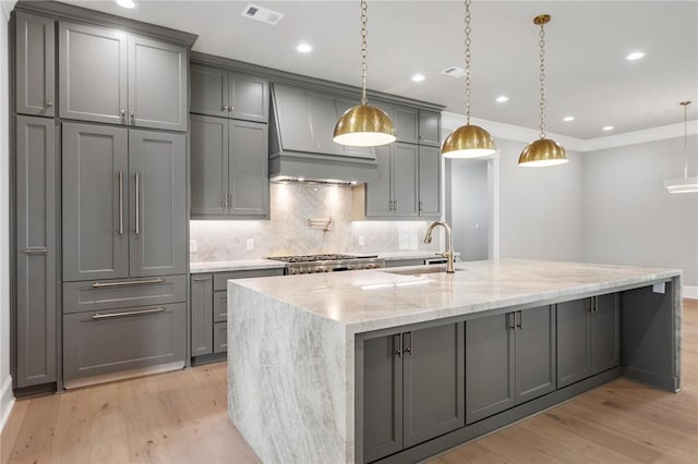 4724 Concordia Dr, Bryan, TX 77802 - kitchen featuring stainless steel gas cooktop, a sink, visible vents, custom exhaust hood, and gray cabinetry