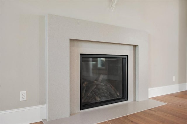 4724 Concordia Dr, Bryan, TX 77802 - interior details with a glass covered fireplace, wood finished floors, and baseboards