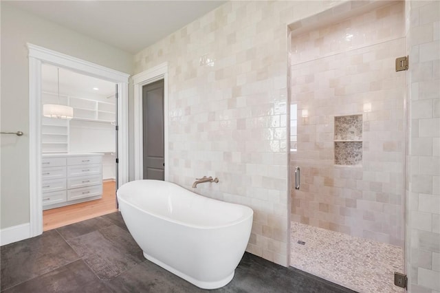 4724 Concordia Dr, Bryan, TX 77802 - bathroom featuring a walk in closet, tile walls, a freestanding tub, and a stall shower