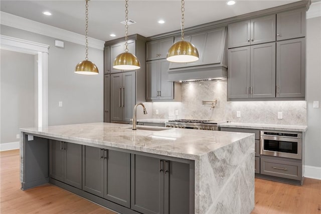 4724 Concordia Dr, Bryan, TX 77802 - kitchen with appliances with stainless steel finishes, gray cabinetry, a sink, and light wood finished floors