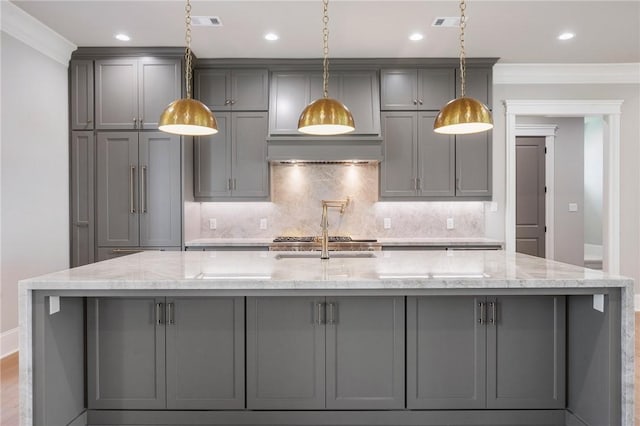 4724 Concordia Dr, Bryan, TX 77802 - kitchen with a large island, ornamental molding, decorative backsplash, gray cabinetry, and custom exhaust hood