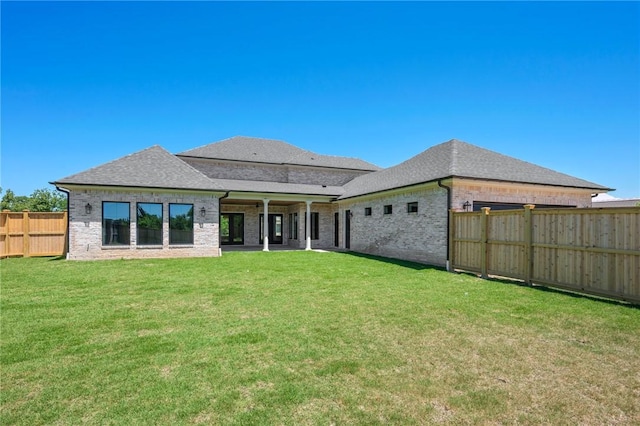 4724 Concordia Dr, Bryan, TX 77802 - rear view of house featuring a fenced backyard, brick siding, a shingled roof, and a lawn