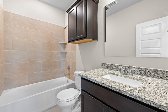 full bathroom featuring vanity, tiled shower / bath combo, and toilet