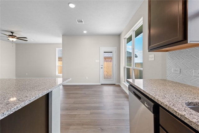 kitchen with light hardwood / wood-style flooring, stainless steel dishwasher, ceiling fan, dark brown cabinets, and light stone counters