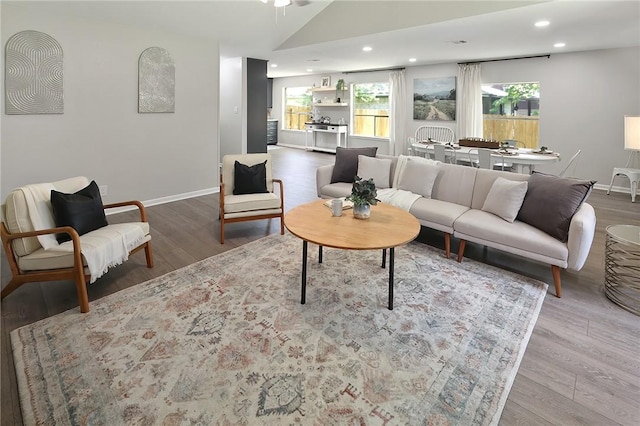 living area with a wealth of natural light, baseboards, and wood finished floors