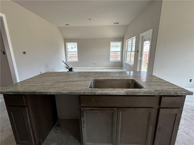 3140 Charge Ln, Bryan, TX 77808 - kitchen with vaulted ceiling, open floor plan, an island with sink, and dark stone countertops