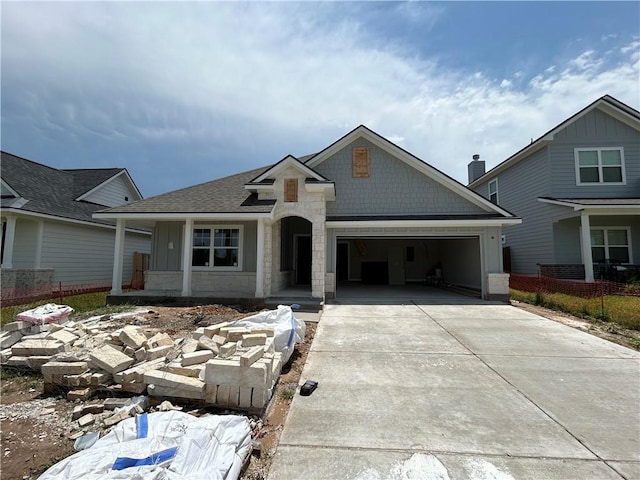 3140 Charge Ln, Bryan, TX 77808 - view of front of home with an attached garage, concrete driveway, roof with shingles, and stone siding