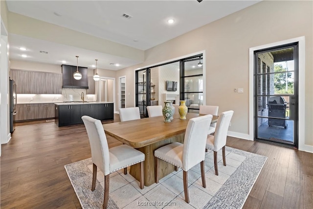 dining space with light hardwood / wood-style flooring and sink