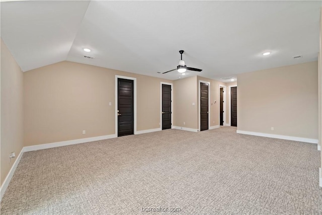 interior space featuring ceiling fan, light colored carpet, and vaulted ceiling