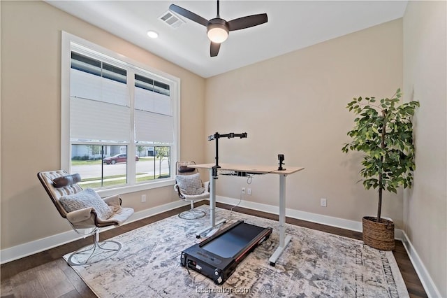 exercise area featuring ceiling fan and dark wood-type flooring