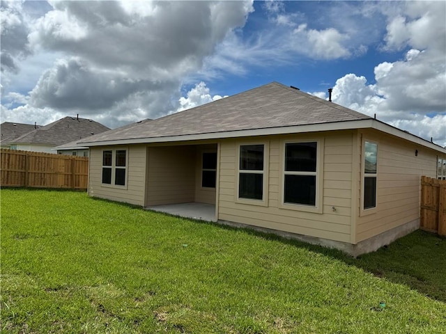 back of property with a lawn and a patio