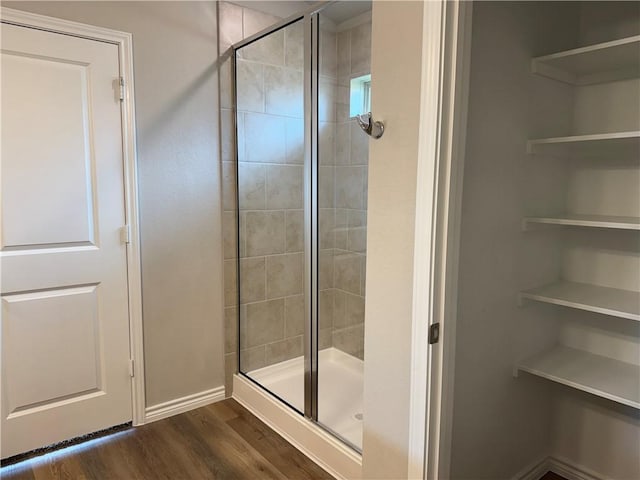 bathroom with hardwood / wood-style floors and an enclosed shower