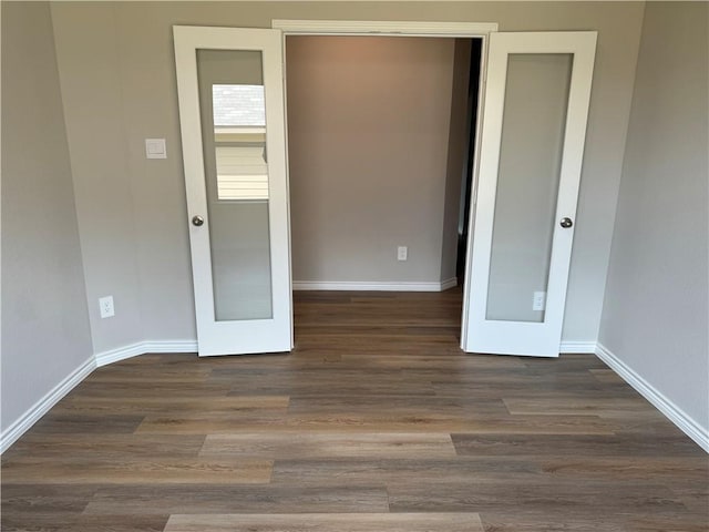 unfurnished bedroom featuring french doors and dark wood-type flooring