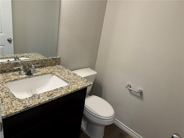 bathroom featuring vanity, hardwood / wood-style flooring, and toilet