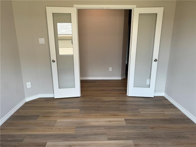 unfurnished bedroom with dark hardwood / wood-style floors and french doors