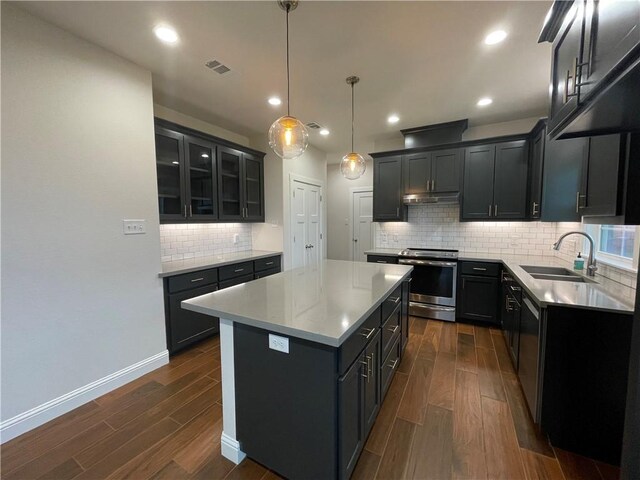 1692 Henry Prairie Rd, Franklin, TX 77856 - kitchen featuring appliances with stainless steel finishes, under cabinet range hood, dark wood finished floors, a center island, and recessed lighting