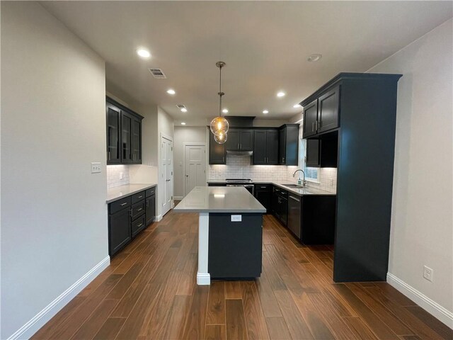 1692 Henry Prairie Rd, Franklin, TX 77856 - kitchen featuring dark wood finished floors, tasteful backsplash, a kitchen island, light countertops, and recessed lighting