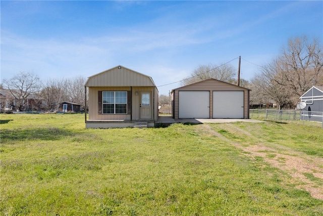 view of front of home with an outdoor structure, a front lawn, a garage, and fence