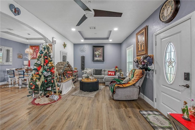 interior space featuring a raised ceiling, a healthy amount of sunlight, hardwood / wood-style floors, and ceiling fan