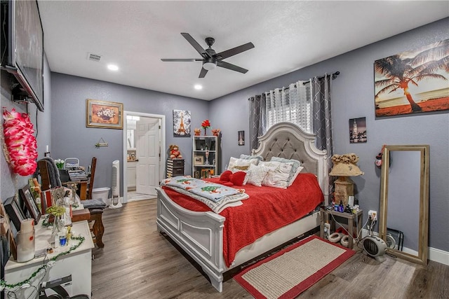 bedroom with dark hardwood / wood-style floors, connected bathroom, and ceiling fan