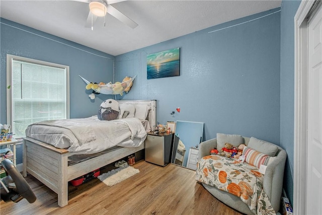 bedroom with light hardwood / wood-style floors and ceiling fan