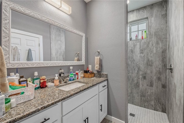 bathroom with vanity and tiled shower