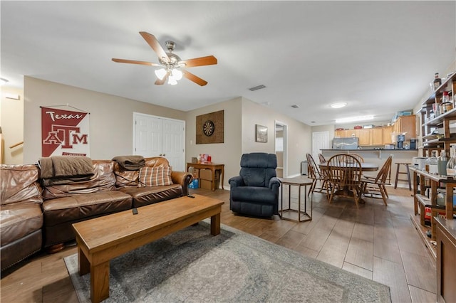 living room with ceiling fan and light wood-type flooring