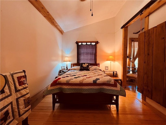 bedroom with light wood-type flooring and vaulted ceiling